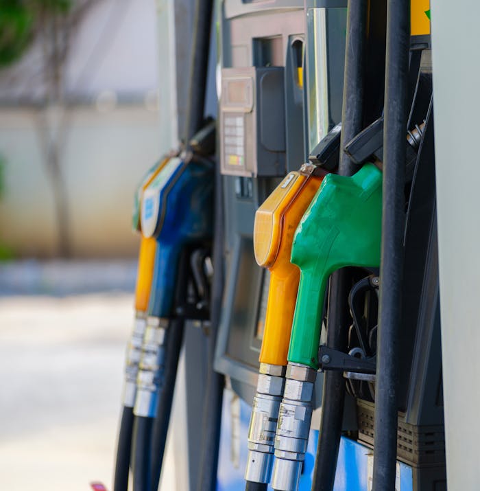 Close-up of vibrant fuel nozzles at a gasoline station showcasing diesel, gas, and petrol options.